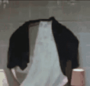 a person 's underwear is hanging on a wall next to a cup .