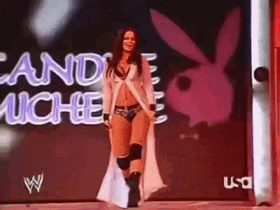 a woman is walking in front of a playboy bunny sign