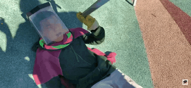 a person laying on the ground with a sword and a shield on their head