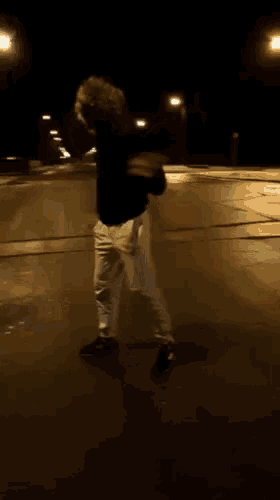 a blurry picture of a person standing on the street at night