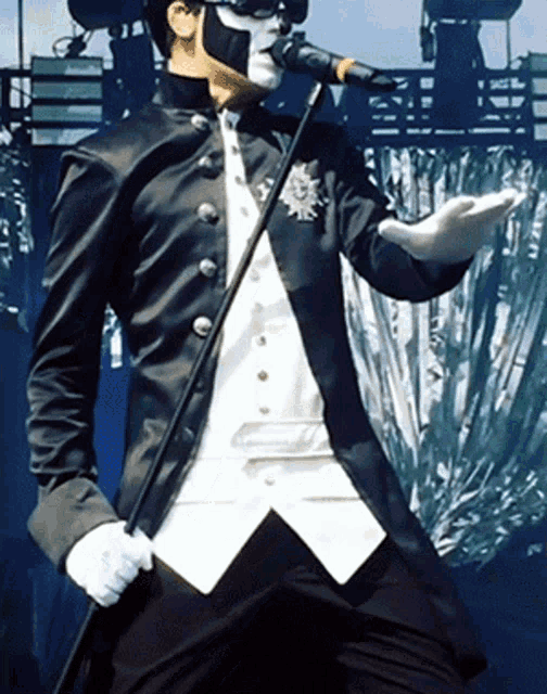 a man in a black and white suit singing into a microphone