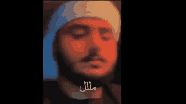 a close up of a man 's face with arabic writing