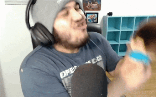 a man wearing headphones and a blue shirt that says ' exper ' on it