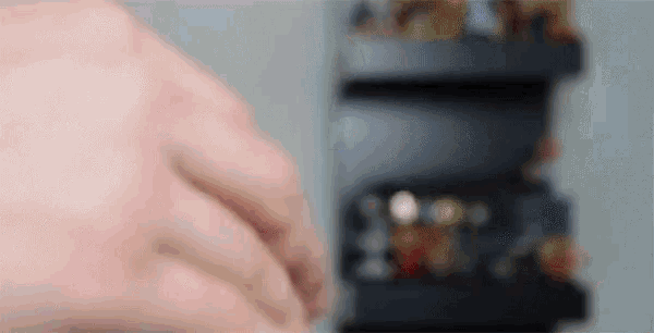 a close up of a person 's hand reaching into a container of coins .