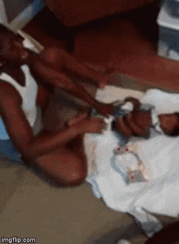 a woman is changing a baby 's diaper while sitting on the floor