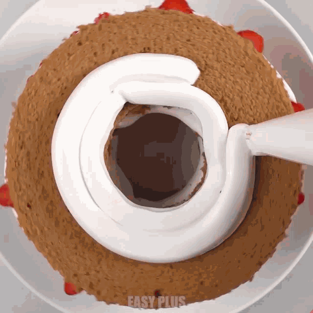 a cake with strawberries and whipped cream is on a plate with easy plus written on it