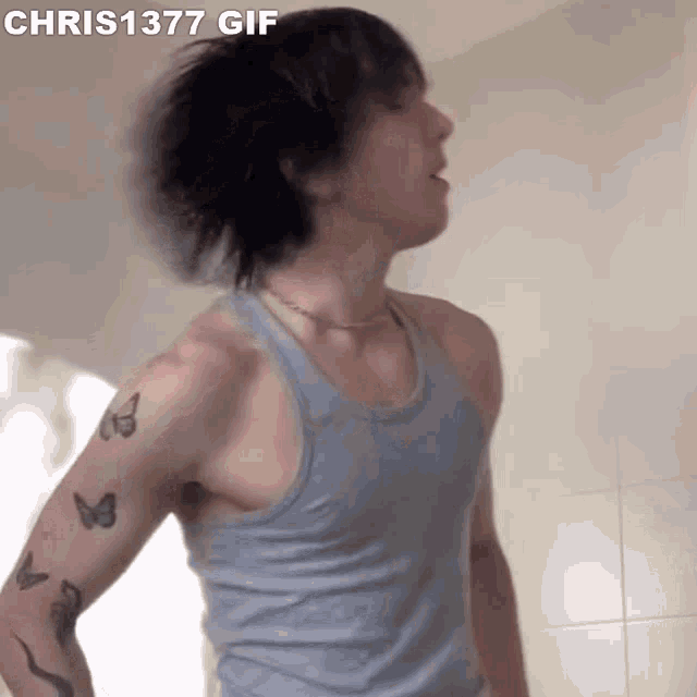 a man in a tank top has a tattoo of butterflies on his shoulder