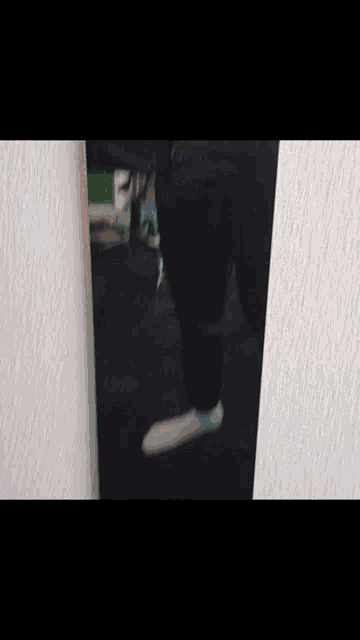 a person wearing white socks is standing in front of a white wall .