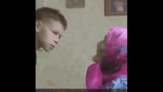 a boy and a girl are sitting at a table and kissing .