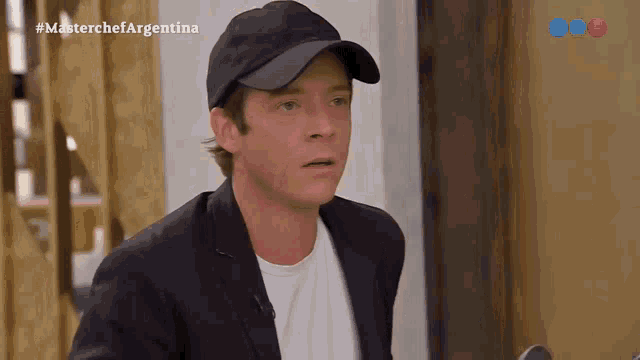 a man wearing a black hat and a suit is on a tv show called masterchef argentina