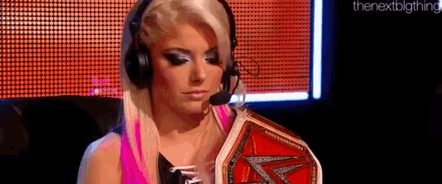 a woman wearing headphones is holding a championship belt .