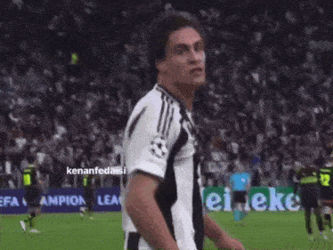 a soccer player celebrates a goal in front of a crowd and a sign that says ' kennfedaisi ' on it