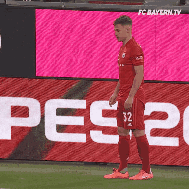 a soccer player wearing a red jersey with the number 32 on it