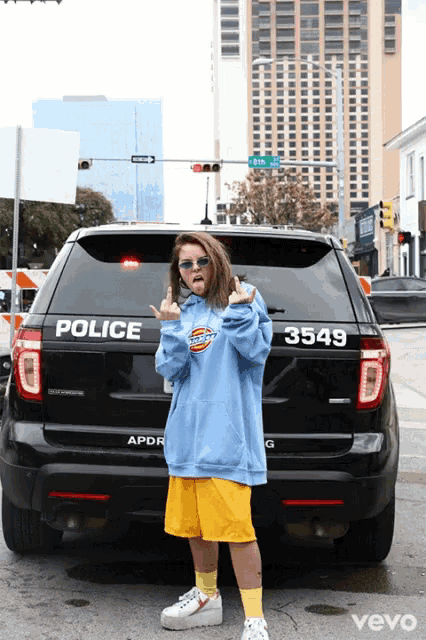 a woman stands in front of a police car that says 3549