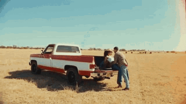 a man and woman are hugging in the back of a truck