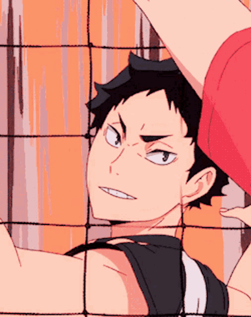 a close up of a person behind a volleyball net with a red shirt on
