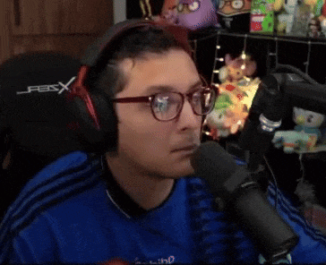 a man wearing headphones and glasses is talking into a mic