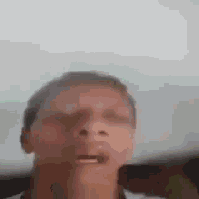 a man is making a funny face in a blurry photo .