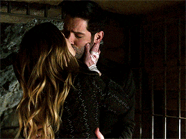 a man is kissing a woman on the cheek in a dark room