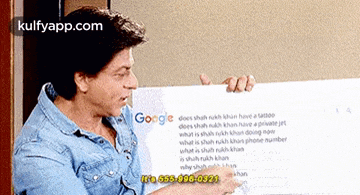 a man is holding a piece of paper in front of a google page