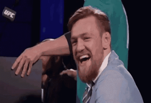a man with a beard is laughing while sitting in a chair .