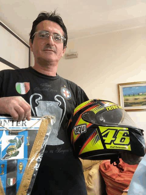 a man holding a helmet that says agu 46 on it