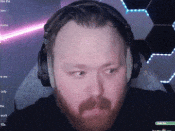 a man with a beard wearing headphones looks at the camera