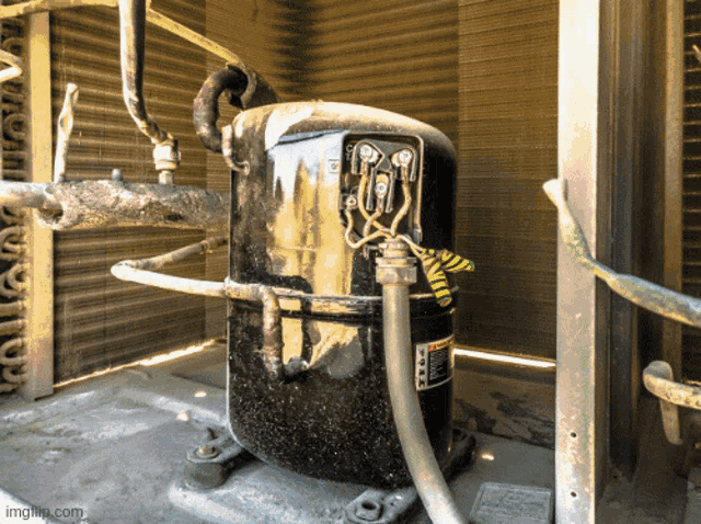 a large black compressor with a yellow and green warning tape on it