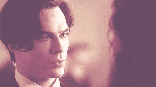 a close up of a man in a suit looking at a woman .