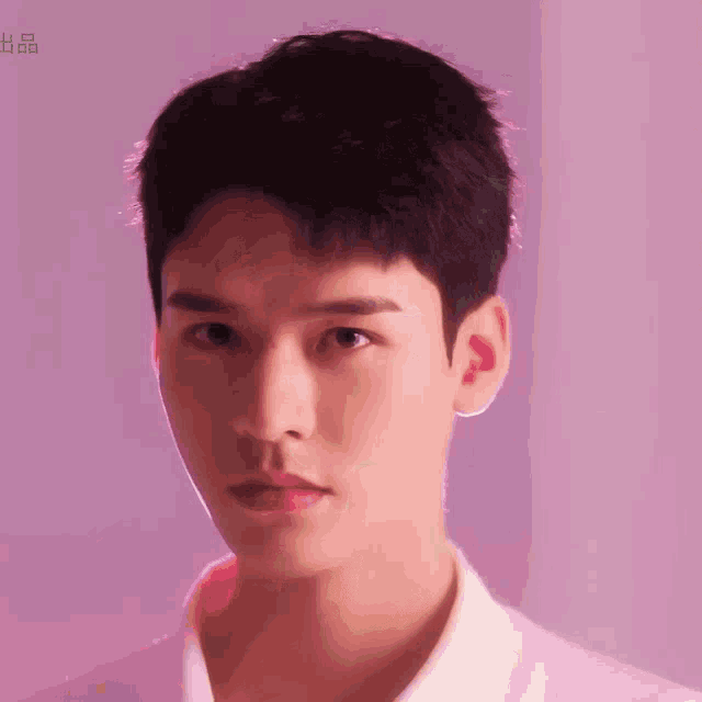 a close up of a young man 's face against a purple background