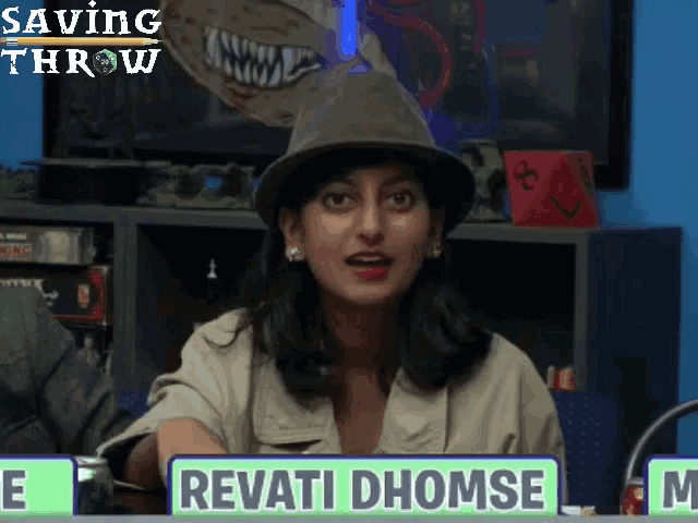 a woman sitting at a table with a sign that says revati dhomse on it