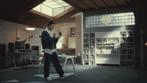 a man standing in a room with a ceiling that has a skylight