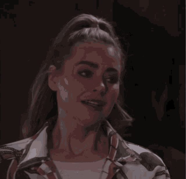 a woman with her hair in a ponytail is wearing a white shirt