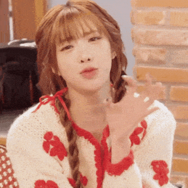 a woman in a white sweater with red flowers on the sleeves