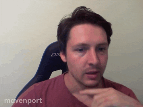 a man in a red shirt is sitting in a chair with the word dx on it