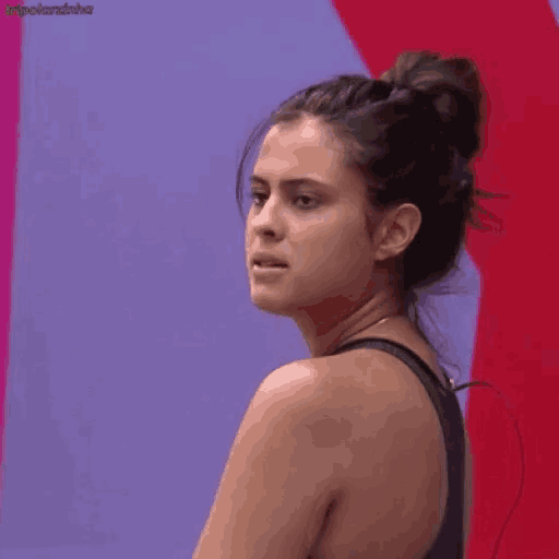 a woman with her hair in a bun is looking over her shoulder