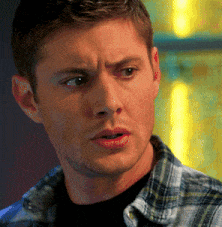 a man in a plaid shirt looks at the camera