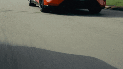 a red sports car is driving down a road with a license plate that says sbn188u