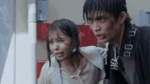 a man and a woman are standing next to each other in the rain