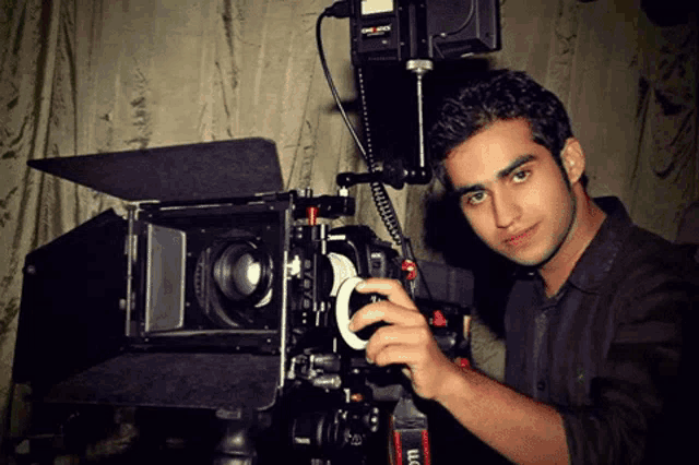 a man adjusts a camera with a canon logo on the side
