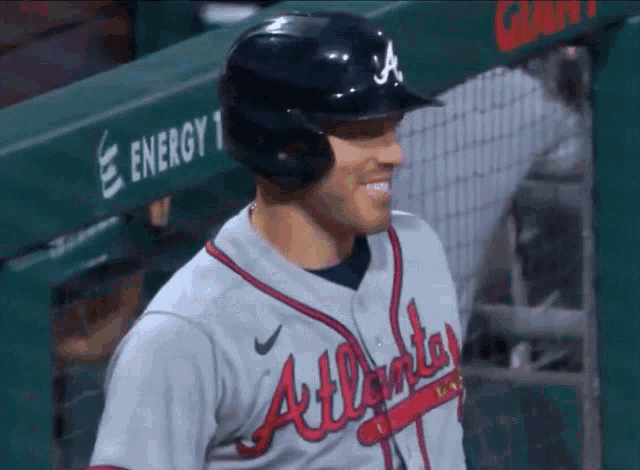 a baseball player wearing a helmet and an atlanta jersey