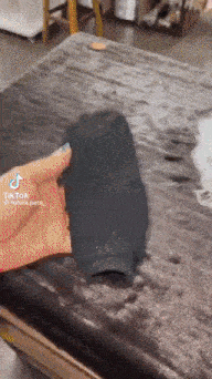 a person is holding a black sock in their hand .