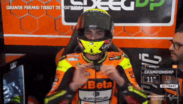 a motorcycle racer wearing a helmet and a beta racing jacket