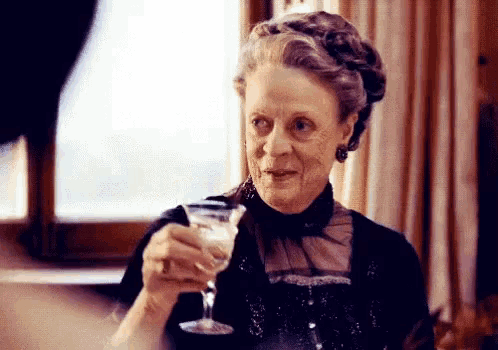 a woman is holding a martini glass in her hand and smiling .