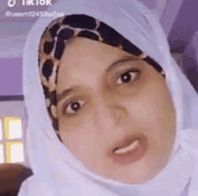 a close up of a woman wearing a hijab and a headband .