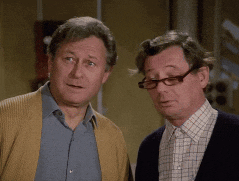 two men standing next to each other one wearing glasses