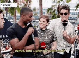 a group of people are standing around a man holding a microphone and a woman is holding a microphone .