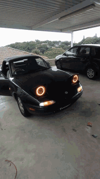a black car with a license plate that says ' volkswagen ' on it is parked in a garage