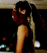 a woman is wearing a red scarf around her face