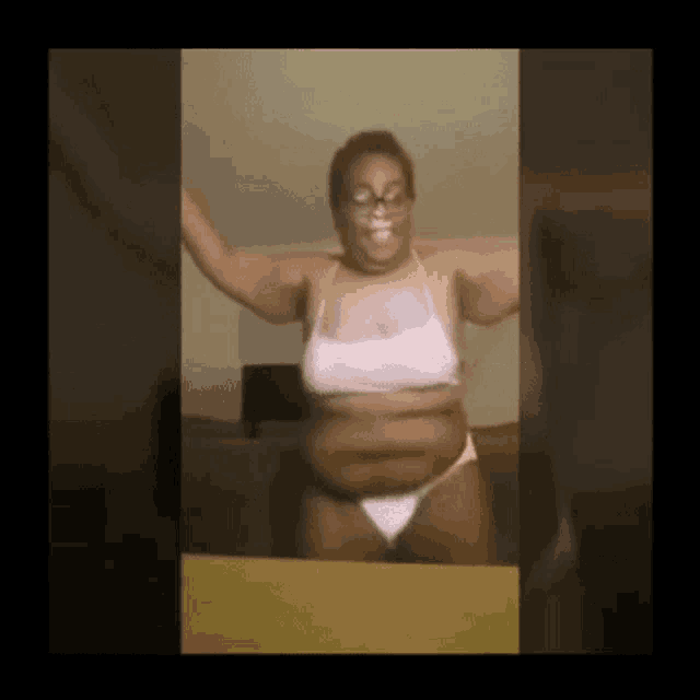 a woman in a bikini is dancing with her arms outstretched .